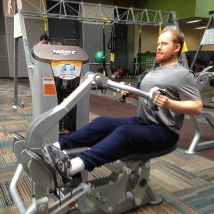 Robert Jenkins working out on a seated weight machine at 24 Hour Fitness
