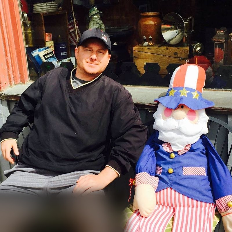 Robert Jenkins sitting beside an Uncle Sam figure outside Beau Jo's Pizza in Idaho Springs, Colorado