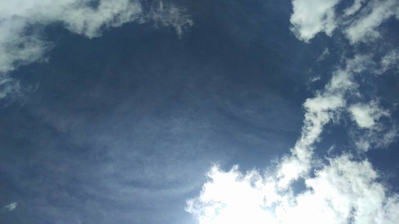 Looking up at blue sky and white clouds from the summit of Mount Blue Sky