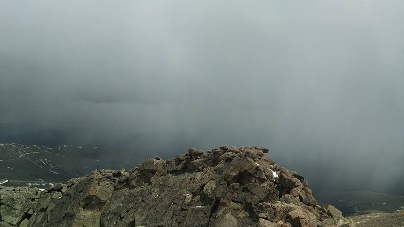Rocky summit of Mount Blue Sky with a snow squall moving through