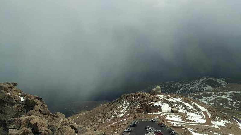 Storm clouds rolling over the summit observatory and parking lot on Mount Blue Sky, Colorado