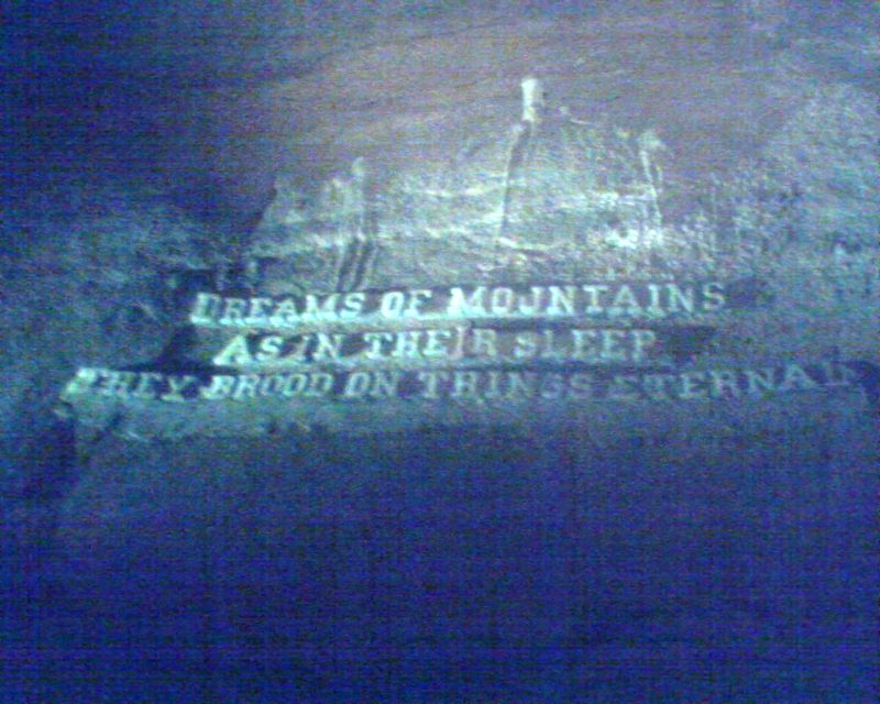 Carved inscription on a cave wall at Cave of the Winds reading: Dreams of mountains, as in their sleep they brood on things eternal