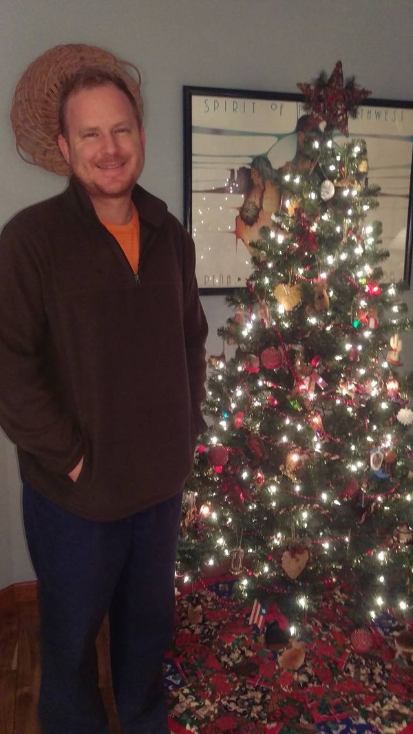 Robert Jenkins smiling beside a lit Christmas tree